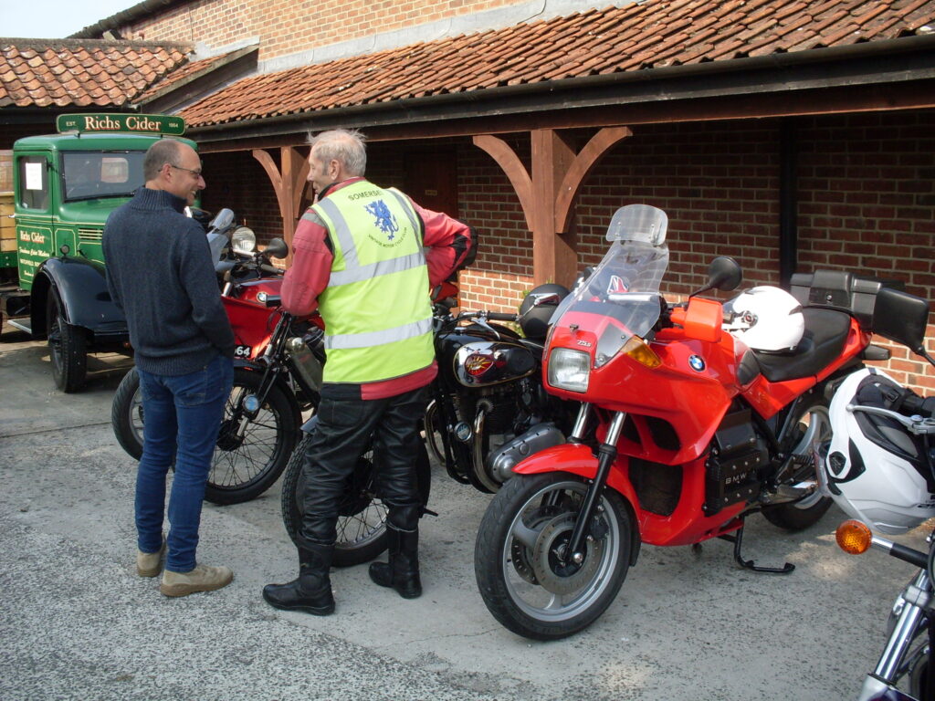 Two men engrossed in coversation with their backs to a very smart BMW K75 750cc motorbike
