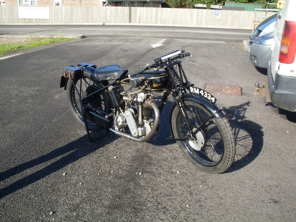 A portrait of a black-painted motorbike typical of the 1920s