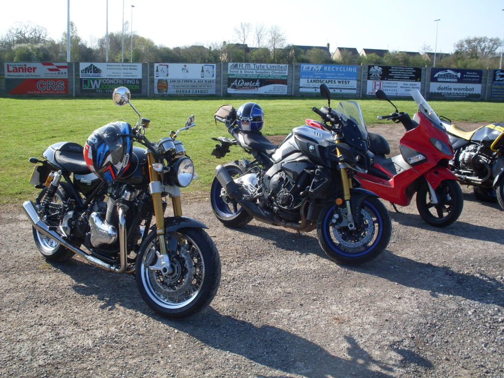 Three very modern machines! (Norton, Yamaha and a red scooter) parked together.