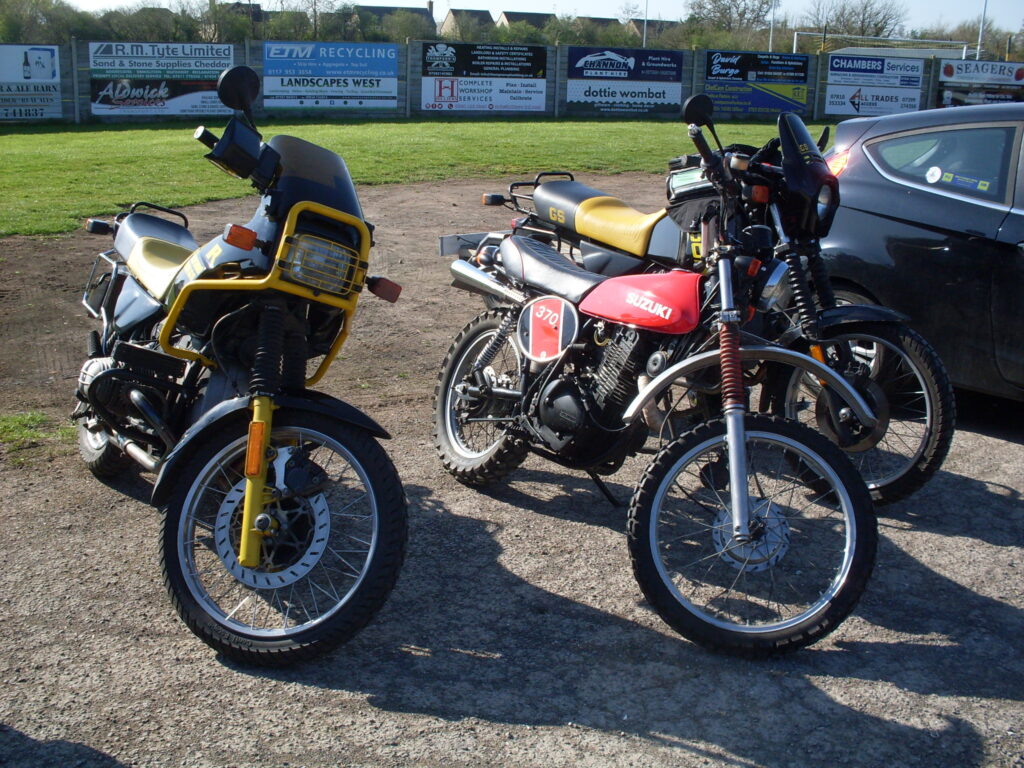 Three 'off road' style motorcycles, a red 370cc Suxuki trail bike with big (and comparatively cumbersome) BMW GS machines on either side